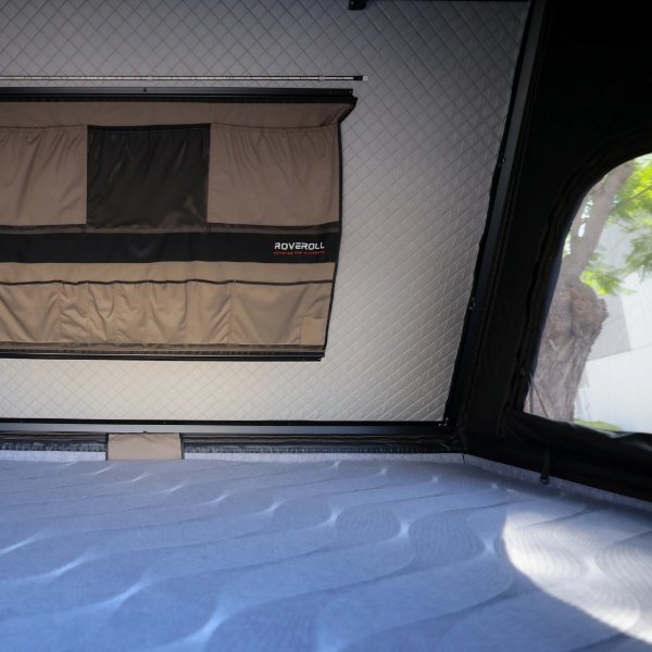 Close-up of interior storage pockets and LED light strip in ROVEROLL Aluminum Side Opening Hard Roof Top Tent